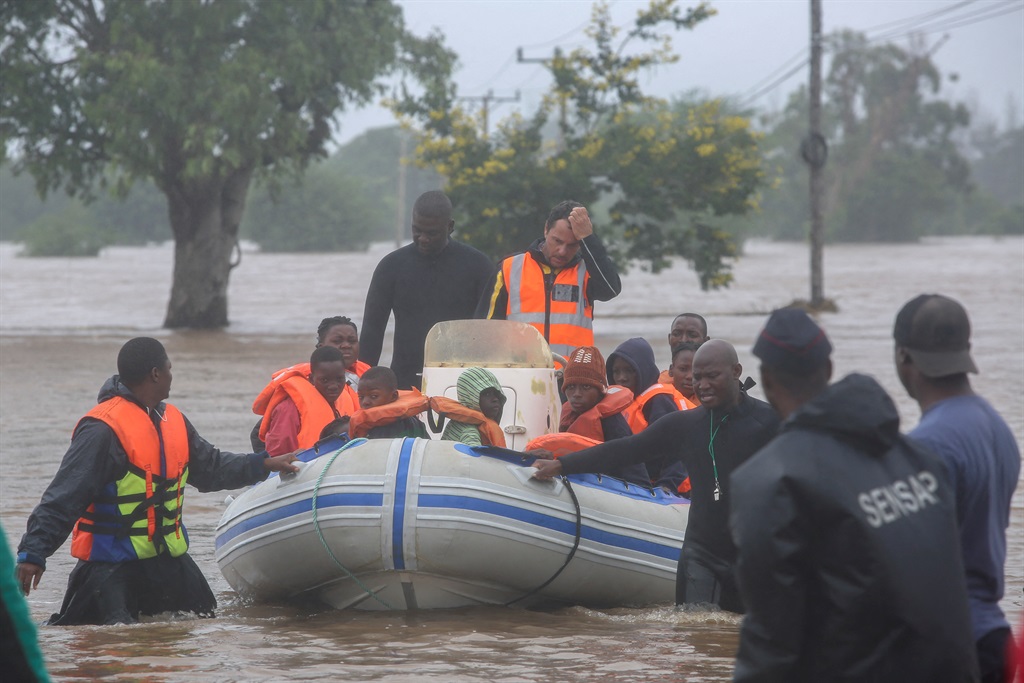 Rescue personnel evacuate residents on boat from the floods caused by heavy rain in the Boane district of Maputo on 11 February 2023.
