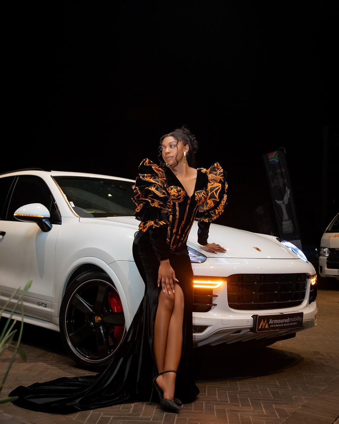 the winner posing in front of her car